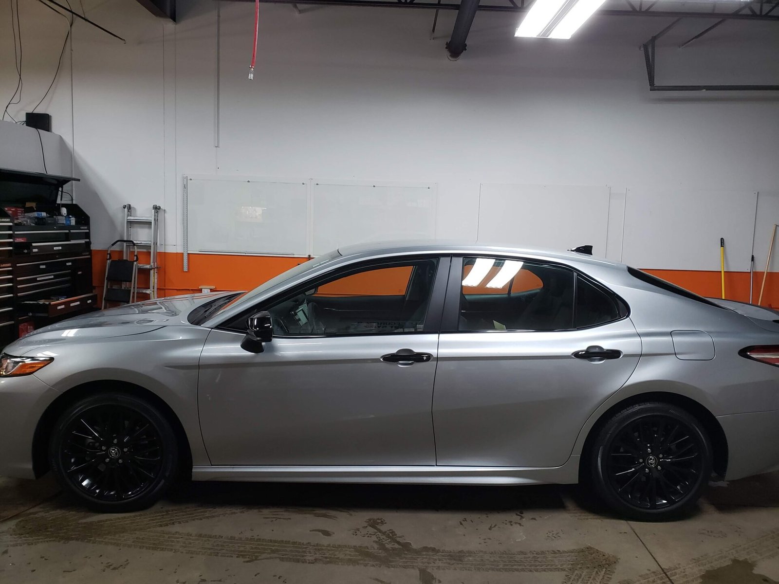 A gray sedan inside the car shop