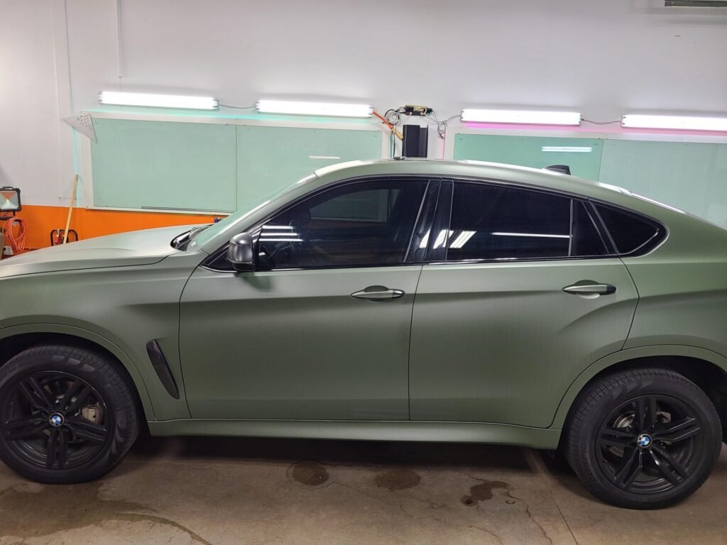 A green car inside the shop