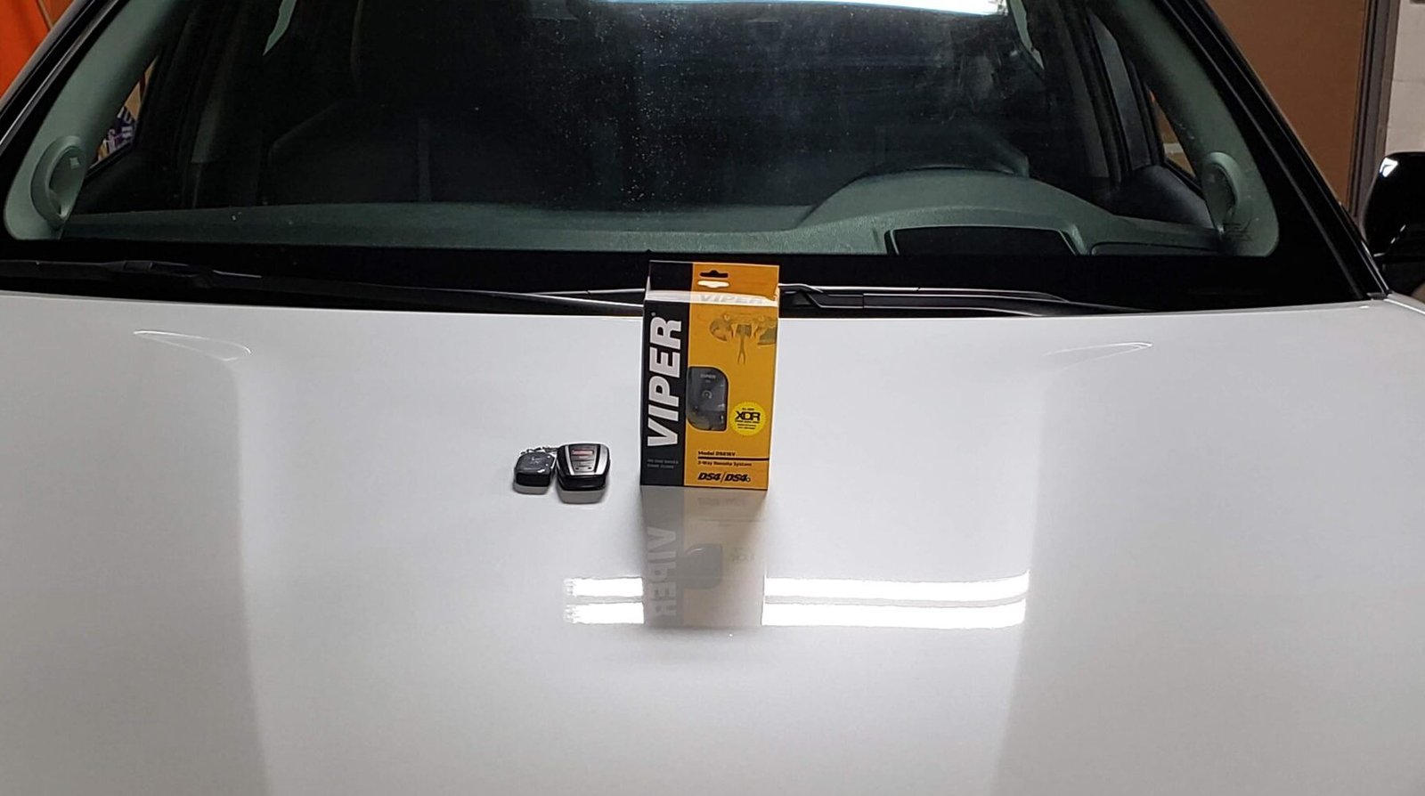 A photo of a remote device on a hood of a car