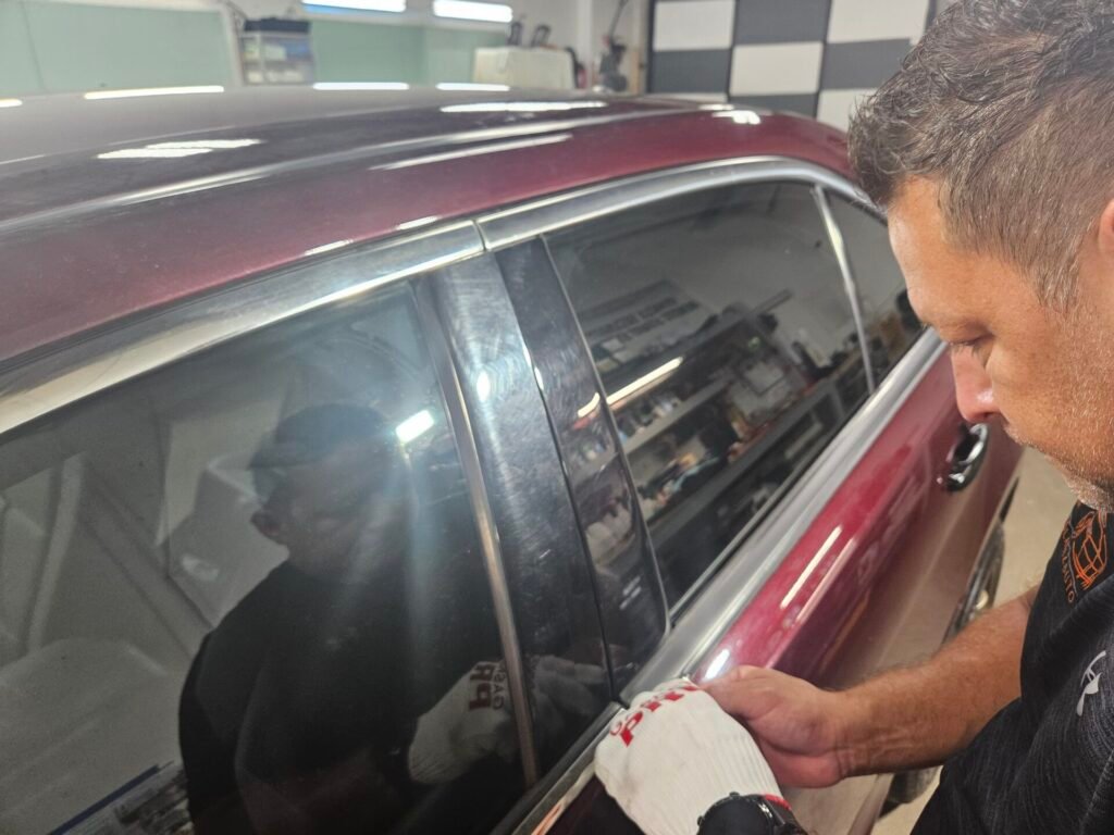 A person touching the side of the car